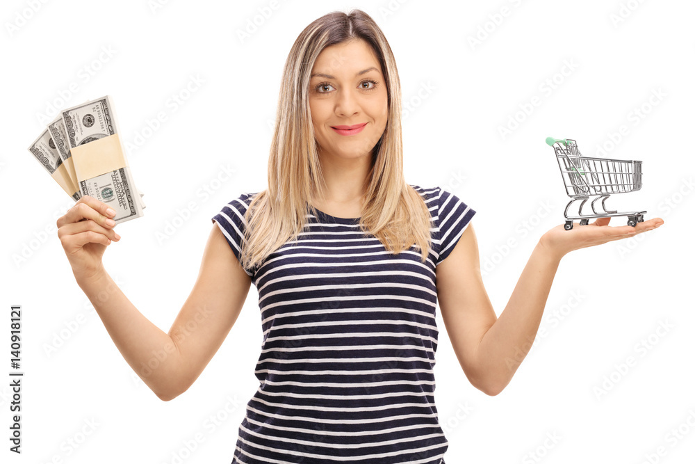 Young woman with bundles of money and empty shopping cart Young woman with bundles of money and empty shopping cart