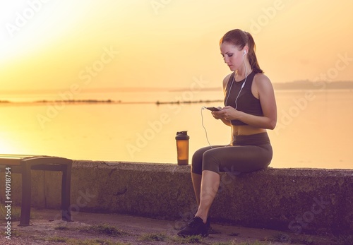 young girl in headphones and with a shaker for a protein cocktail