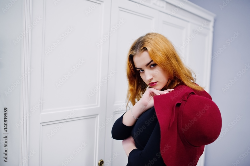 Portrait of fashion red haired girl on red hat and black dress with bright make up posed near white vintage wooden cabinet. Photo toned style Instagram filters. Portrait of fashion red haired girl on red hat and black dress with bright make up posed near white vintage wooden cabinet. Photo toned style Instagram filters.