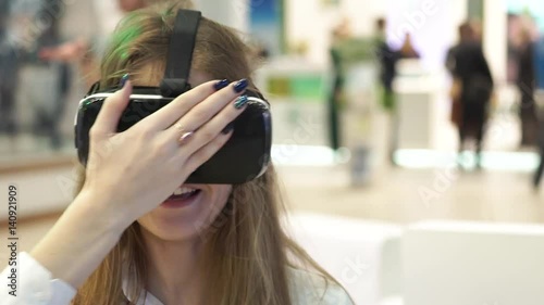technology, virtual reality, entertainment and people concept - happy young woman with virtual reality headset or 3d glasses playing game at home and touching something invisible