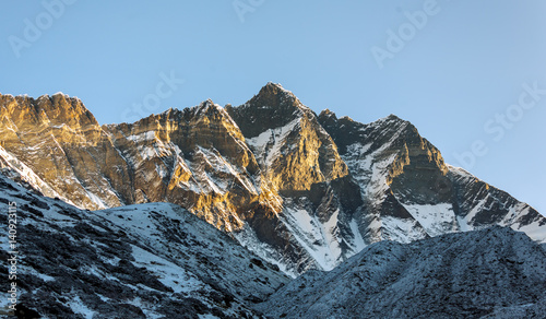 The first rays of the morning sun on the fourth in the world at the height of mount Lhotse (8516 m), view from the Chhukhung Ri - Everest region, Nepal photo