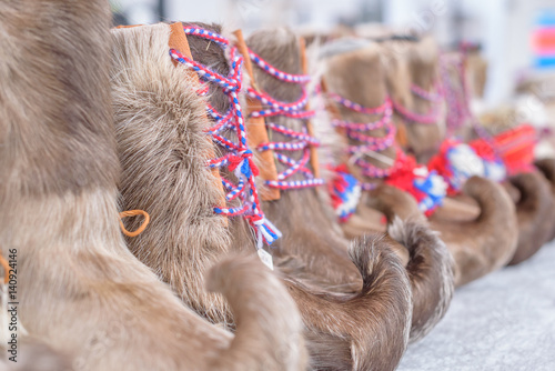 Bild auf Leinwand Row of Traditional Sami Handmade Adult Footwear Komager from Reindeer Fur, Close