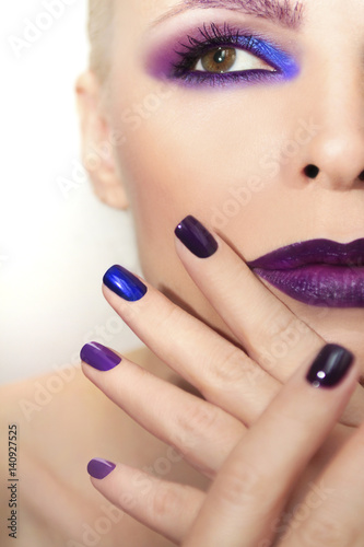 Blue purple fashion multicolored manicure and makeup on a woman in close-up.The nail design.