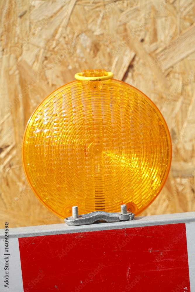 Obraz premium Orange Baustellenlampe an einer Baustellenabsperrung