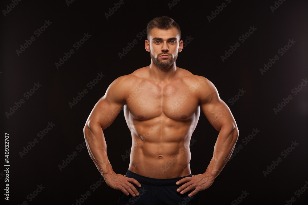 Strong Athletic Man - Fitness Model showing his Torso with six pack abs. isolated on black background with copyspace Strong Athletic Man - Fitness Model showing his Torso with six pack abs. isolated on black background with copyspace