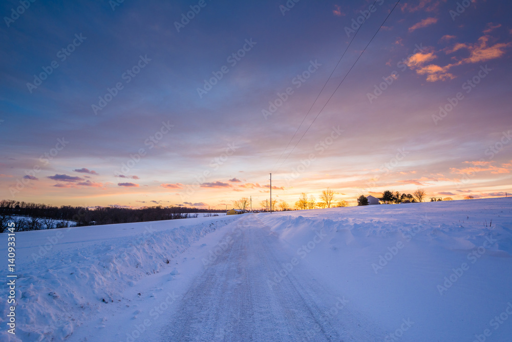 Sunset over a snow covered road  in a rural area of York County, Pennsylvania.
