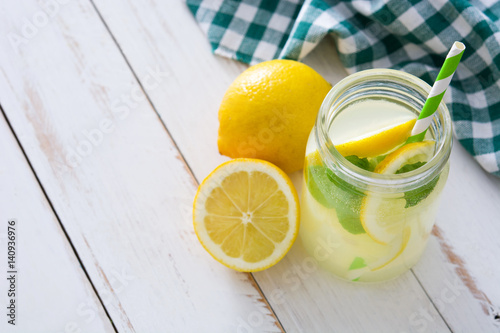 Lemonade drink in a jar glass on white wooden background. Copyspace.
