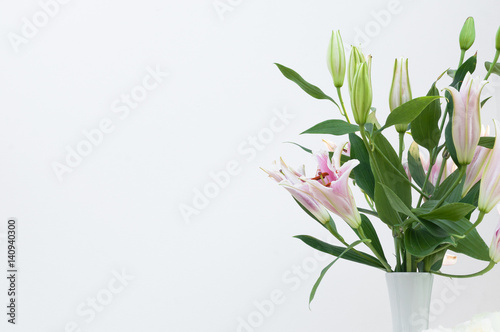 Bouquet of white lilies in a white vase on white background,for background