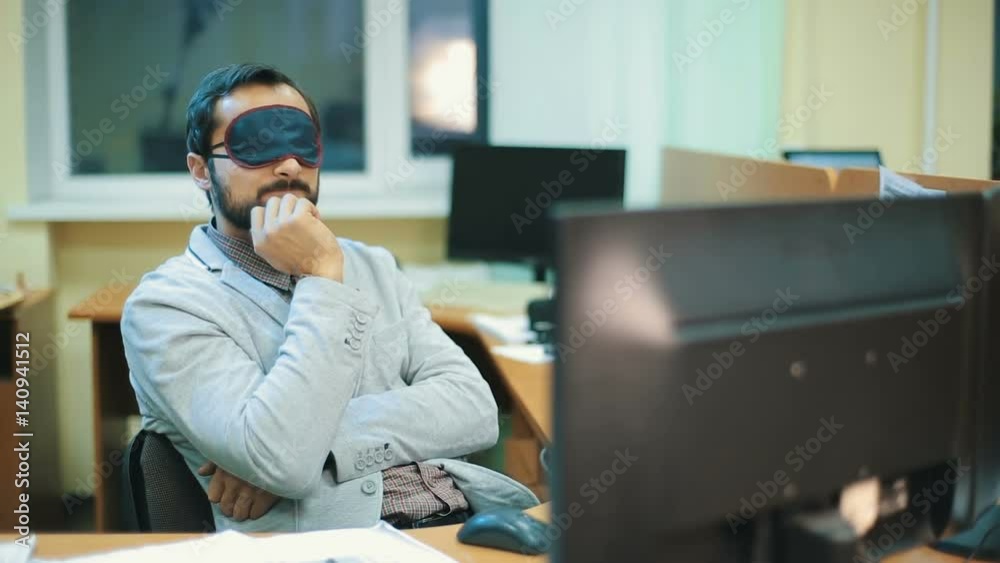 Executive with blindfold sleeping at work