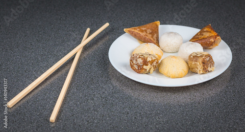 Delicious assortment of homemade Asian pastries. Samosas with a rose flower and banana balls