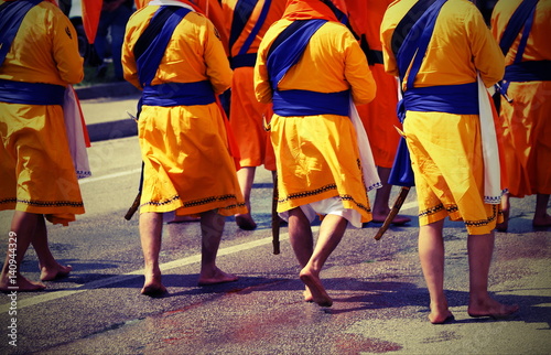 soldiers with orange clothes march through the city during a fes