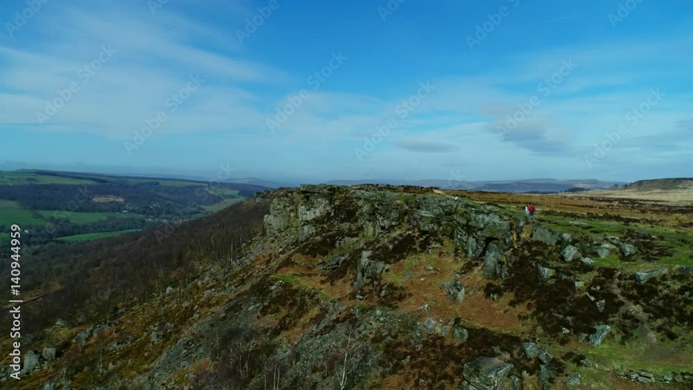 Mountain rocky cliff drop with people walking aerial view of hills in Peak District Mountain rocky cliff drop with people walking aerial view of hills in Peak District