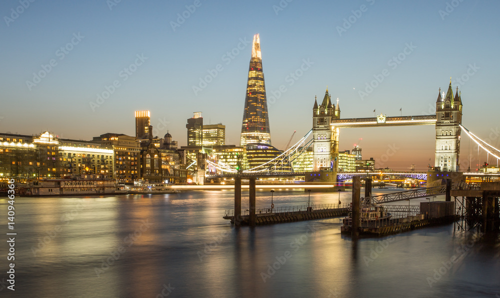 A landscape view of Tower Bridge and The Shard in London at Night.
