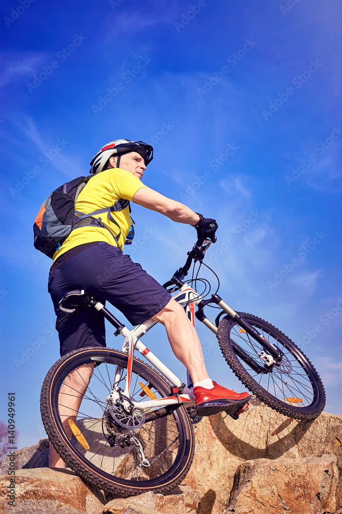 Obraz premium A cyclist who travels in the mountains in summer on a sunny day