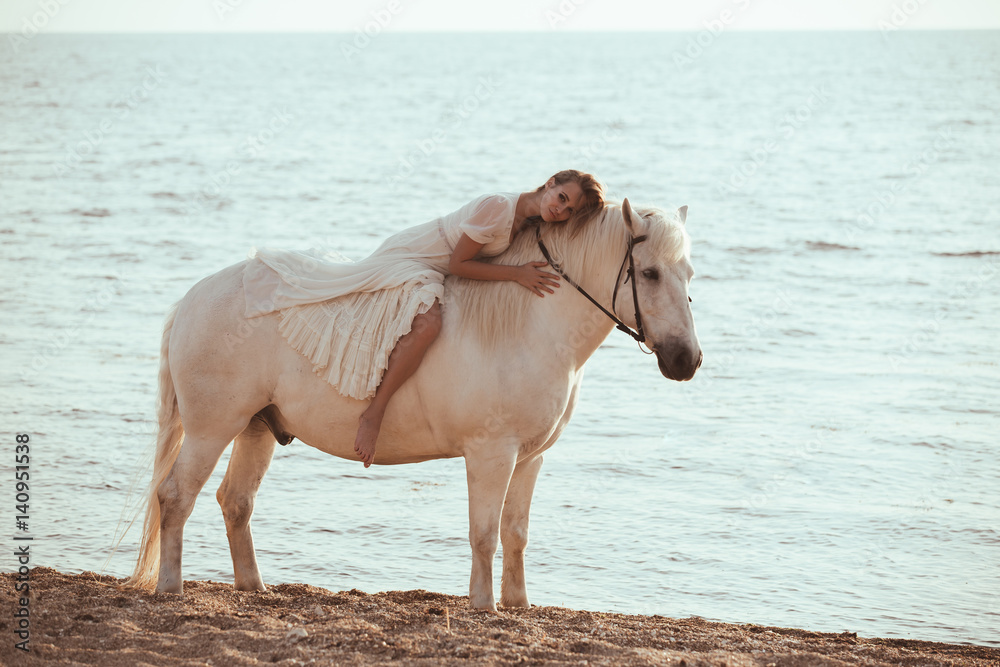 Girl in white dress with horse on the beach Girl in white dress with horse on the beach