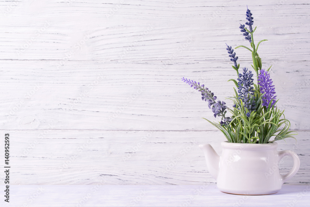 Lavender flowers in watering can, wooden background, copy space - obrazy, fototapety, plakaty 