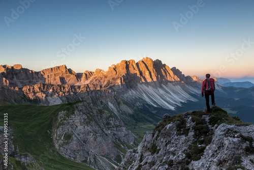 Odle di Eores, Dolomites, South Tyrol, Italy. Hiker admires the sunrise on the Odle photo