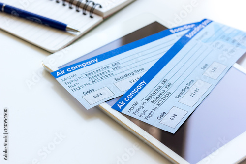 Buying airline tickets online with credit cards on table background