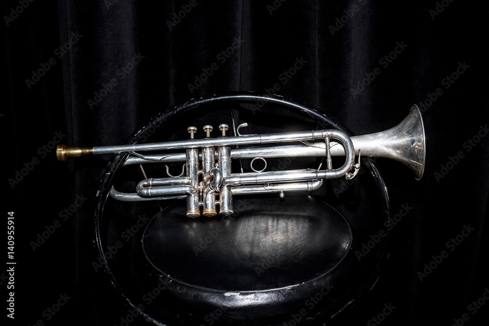 Obraz premium серебристая труба, корнет, на фоне занавеса сцены