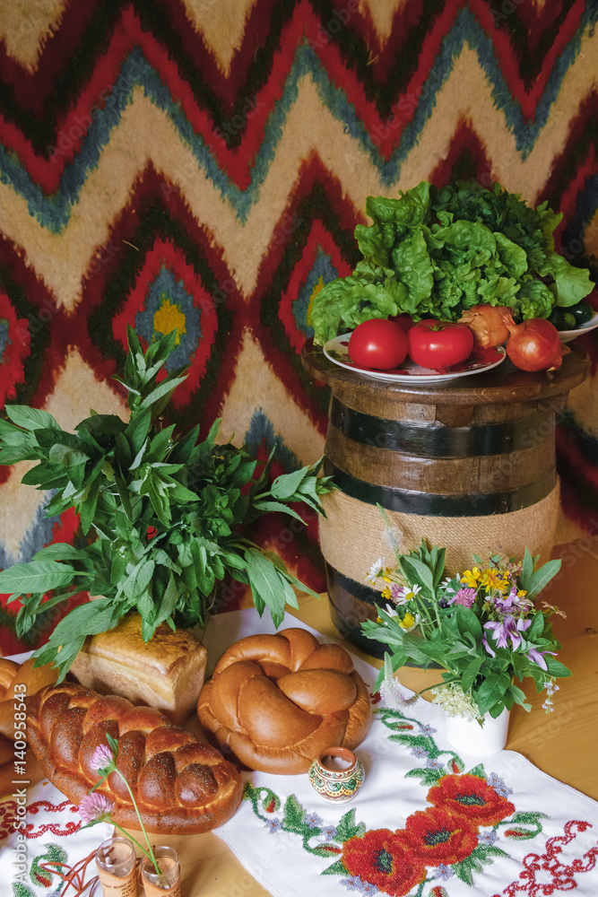 National Ukrainian still-life with loaf, hand-made bread, tomatos, vodka on wooden table