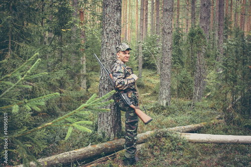 Hunter having rest in forest during hunting season