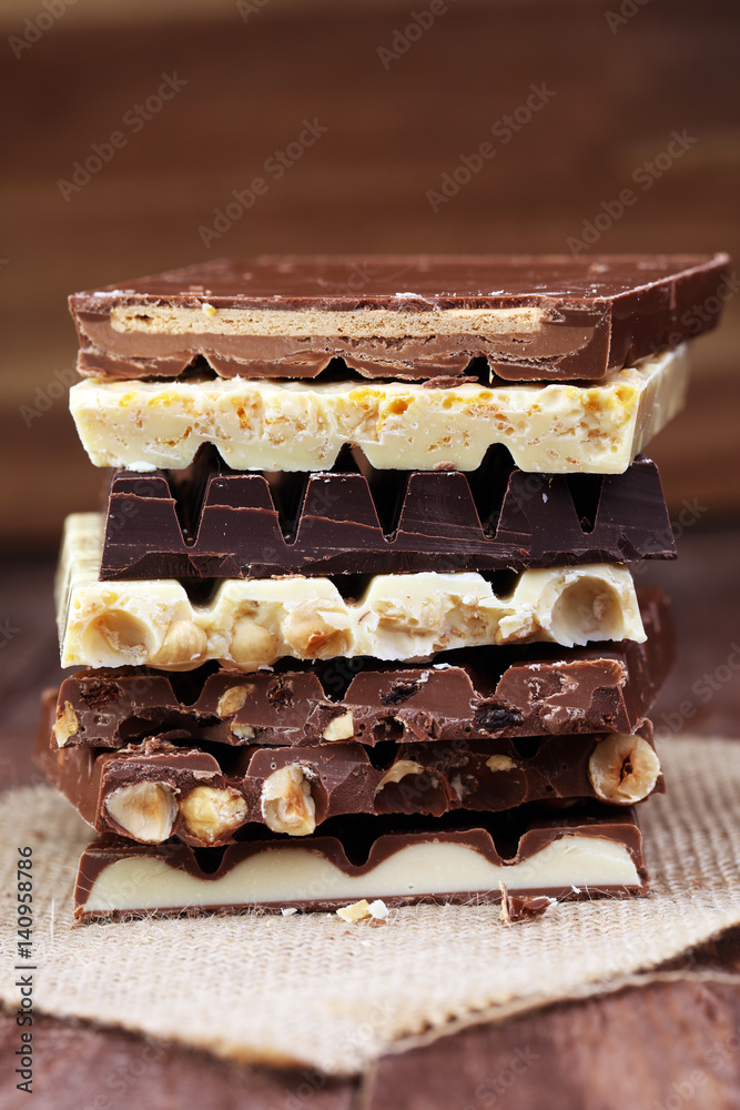 Chocolate bars on a wooden background with chocolate tower Chocolate bars on a wooden background with chocolate tower