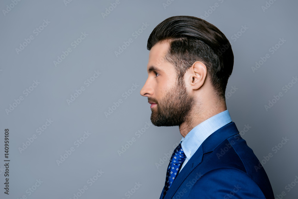 Side view portrait of serious fashionable handsome man in blue suit and tie Side view portrait of serious fashionable handsome man in blue suit and tie
