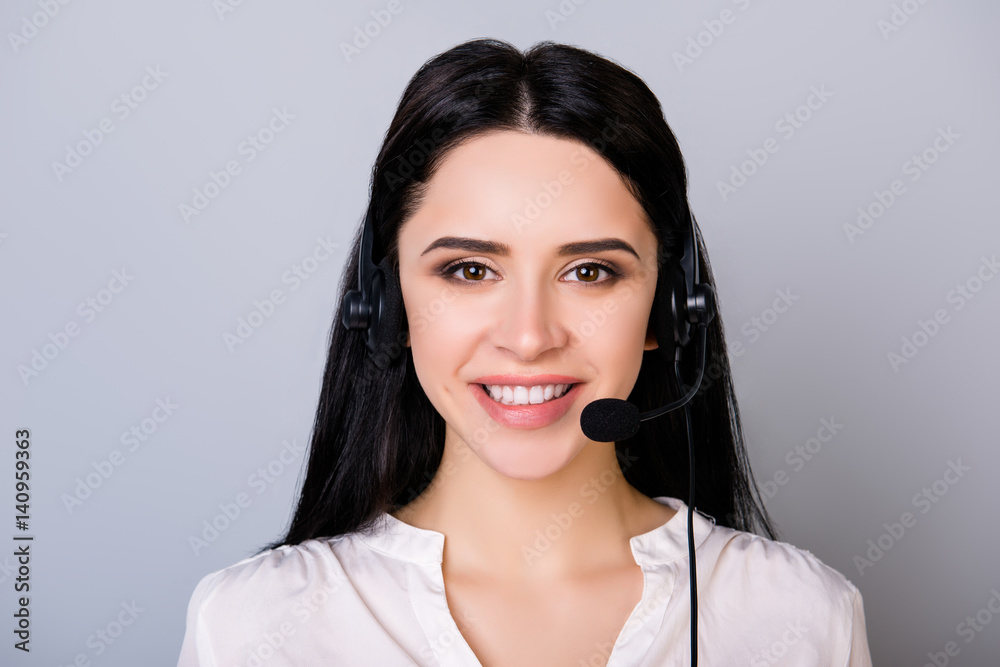 Portrait of young consultant of call center in headphones isolated on gray background Portrait of young consultant of call center in headphones isolated on gray background