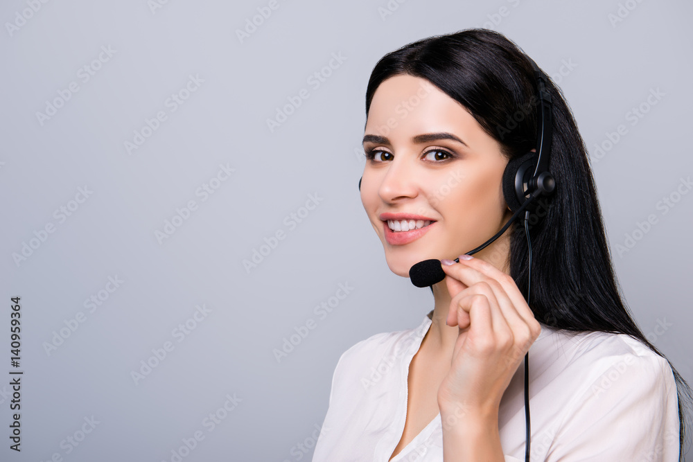 Young consultant in headphones touching microphone and giving advice to a client Young consultant in headphones touching microphone and giving advice to a client