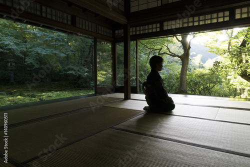 Person meditating in temple, Kyoto, Japan