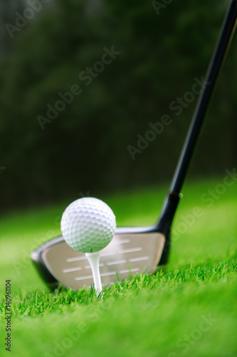 Shot of golf ball with golf club on green grass