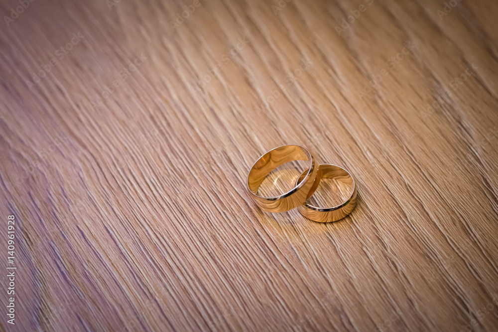 wedding rings on a wooden table wedding rings on a wooden table