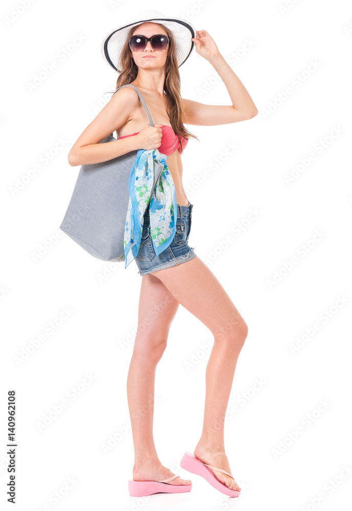 Pretty girl posing in bikini with bag, summer hat and sunglasses, isolated on white background Pretty girl posing in bikini with bag, summer hat and sunglasses, isolated on white background