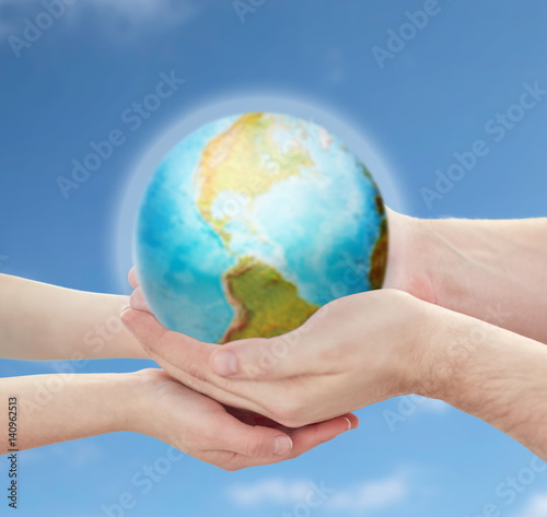 child and father hands holding earth planet