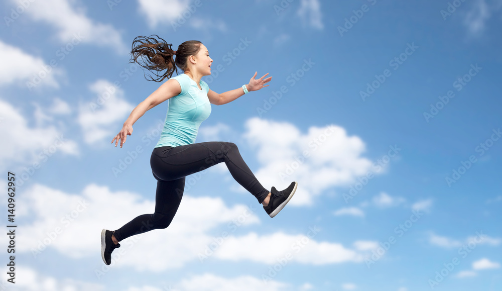 happy sporty young woman jumping in blue sky happy sporty young woman jumping in blue sky