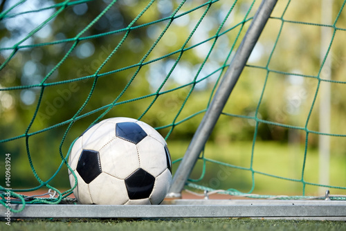 soccer ball at goal net on football field © Syda Productions