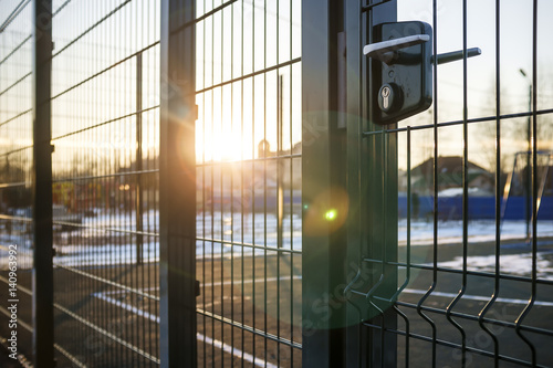 entrance to the playground of fence and the wicket of the welded wire mesh green color with a metal lock and handle