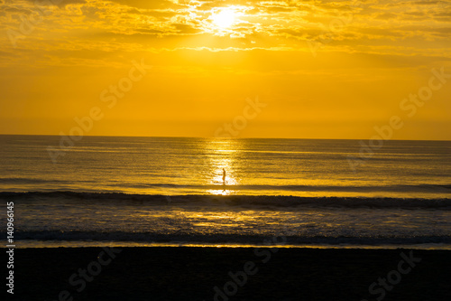 Man Paddle Surfing at Sunrise