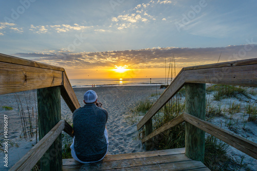 Man Watching and Taking Pictures of the Sunrise