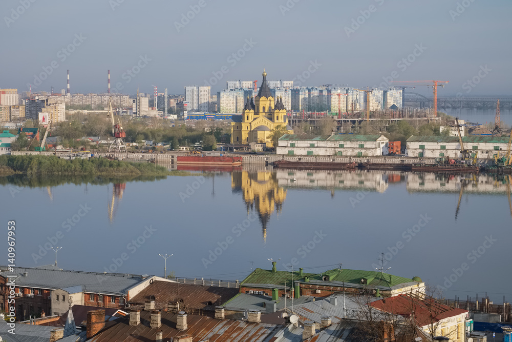 A city landscape with a river, an Orthodox church  in the spring morning. Nizhny Novgorod, Russia