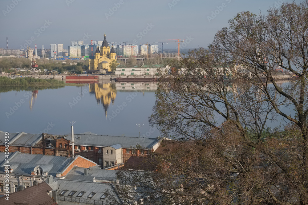 A city landscape with a river, an Orthodox church  in the spring morning. Nizhny Novgorod, Russia