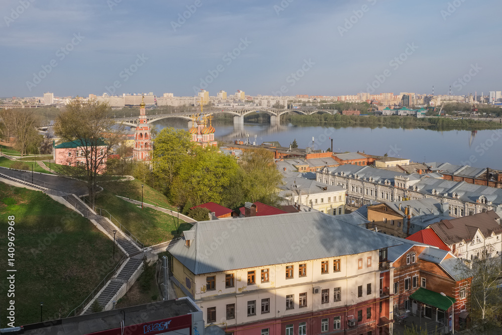 A city landscape with a river, an Orthodox church and bridges in the spring morning. Nizhny Novgorod, Russia