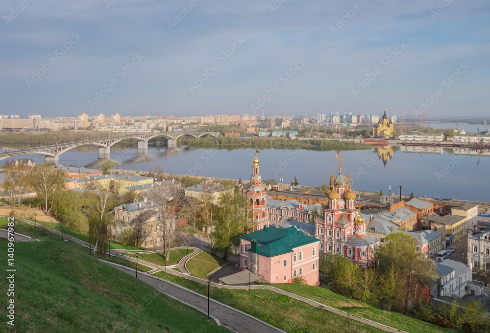 A city landscape with a river, an Orthodox church and bridges in the spring morning. Nizhny Novgorod, Russia