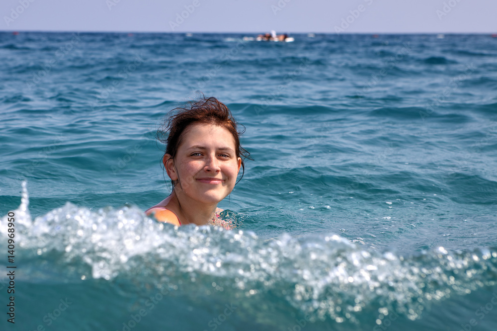 One Caucasian teen girl floundering in the sea water.