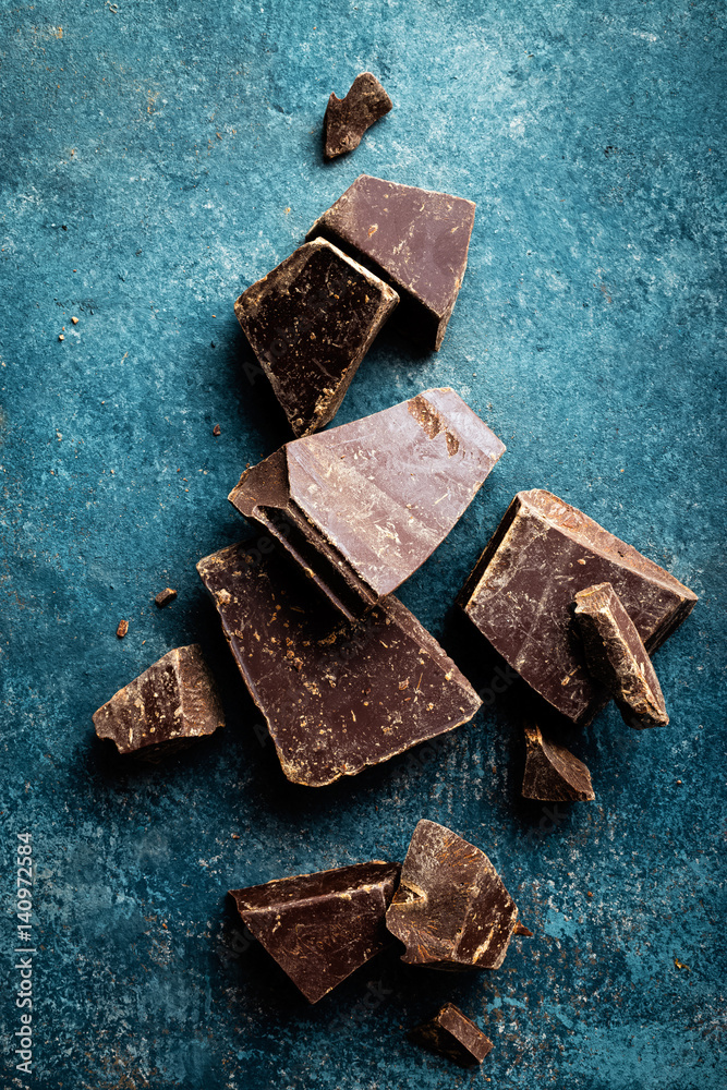 Dark chocolate pieces crushed on a dark background, view from above Dark chocolate pieces crushed on a dark background, view from above