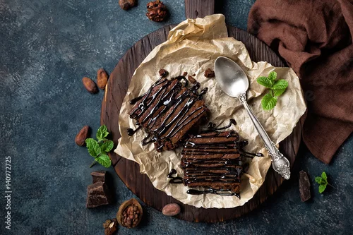 Obraz  z motywem Chocolate brownie cake, dessert with nuts on dark background, directly above, flat lay