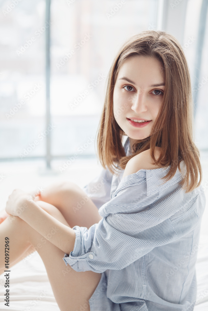 Closeup portrait of young smiling Caucasian woman with long red blonde hair in blue shirt pajama sitting in bed after waking up, indoors at home early morning, lifestyle Closeup portrait of young smiling Caucasian woman with long red blonde hair in blue shirt pajama sitting in bed after waking up, indoors at home early morning, lifestyle