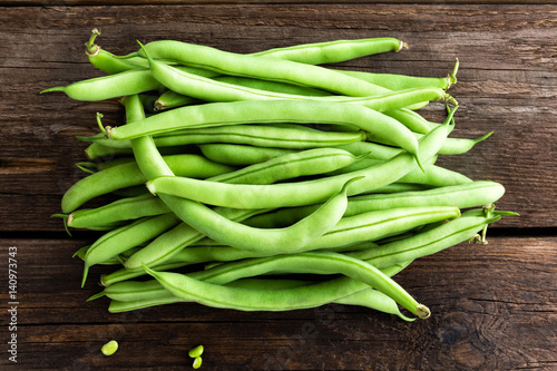 Fresh green beans on dark wooden rustic background top view flat lay