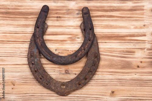 Old rusty vintage good luck horseshoe on wooden tray like background