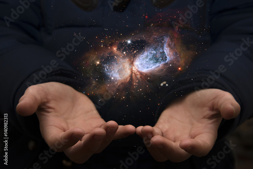 The vast universe in the hands of a child. Elements of this image furnished by NASA.